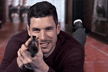 a man laying on the floor holding a gun