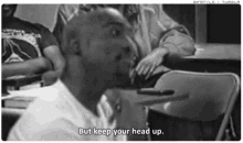 a black and white photo of a man sitting at a table with the words but keep your head up .