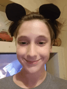 a young girl wearing mickey mouse ears on her head