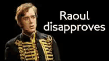 a man is standing in front of a black background with the words raoul disapproves