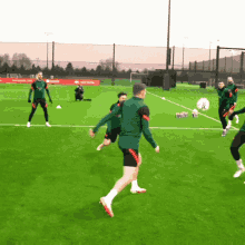 a group of soccer players are playing on a field that has a sign that says ' soccer ' on it