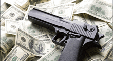 a gun is sitting on top of a pile of money that says 100 dollars