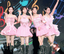 a group of girls in pink dresses are standing next to each other on a stage