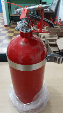 a red fire extinguisher has a tag on it that says ' hm 38 ' on it