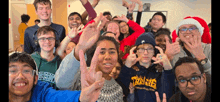 a group of young people are posing for a picture and one of them is wearing a thrasher shirt .