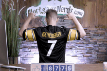 a man in a roethlisberger jersey stands in front of a mortgage nerds sign