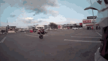 a person is doing a trick on a motorcycle in a parking lot with a coca cola sign in the background