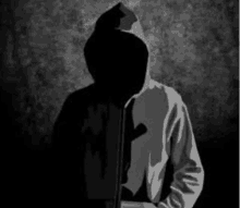 a silhouette of a man in a hoodie with a shadow on his face .