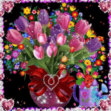 a bouquet of pink and purple flowers in a vase with a heart shaped bow