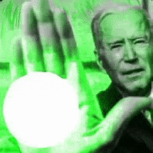 a black and white photo of a man holding a green ball in his hand .