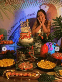 a woman is standing in front of a table full of food and a sign that says " aniversario " on it