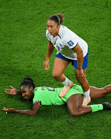 a soccer player with the number 1 on her jersey is helping another player