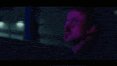 a woman with blue hair is standing next to a man in a dark room