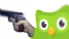 a person is holding a gun next to a green owl .