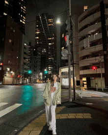 a woman wearing a nike t-shirt is walking down the street at night