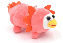 a pink stuffed animal with a yellow beak and orange ears