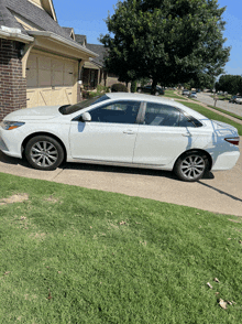 a white car parked in front of a house