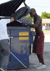 a man standing next to a dumpster with a sticker on it that says do not park on the side of the road