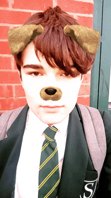 a boy wearing a suit and tie has a dog ear on his face