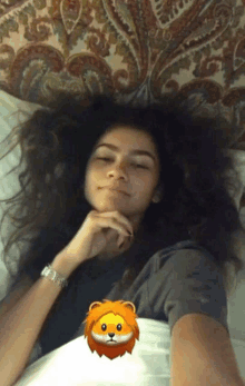 a woman laying on a bed with a lion emoji on the corner