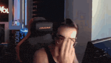 a man in a cougar chair covering his face with his hand