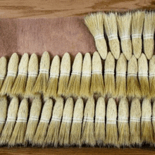 a bunch of brushes sitting on top of a wooden table .