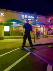 a man is standing in front of a restaurant that says yin tang