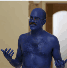 a shirtless man with glasses and a mustache is covered in blue paint