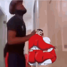 a man is standing in front of a door holding a picture of a cartoon character 's butt .