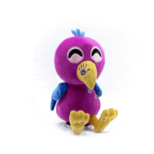 a purple stuffed animal with a yellow beak and blue wings