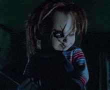 a creepy doll is holding a knife in the dark