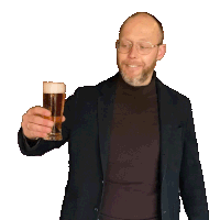 a man in a suit holds a glass of beer and points at it