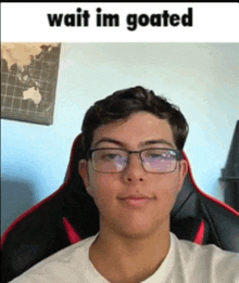 a young man wearing glasses is sitting in a chair and taking a selfie .