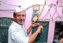 a man wearing a white hat is working on a electrical box