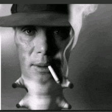 a man in a hat is smoking a cigarette with smoke coming out of his mouth