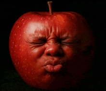 a red apple that looks like a baby 's face with its eyes closed