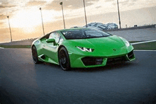 a green lamborghini huracan is driving down a road .