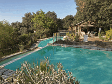 a large swimming pool surrounded by trees and a gazebo