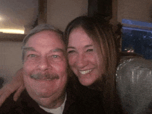 a man and a woman are posing for a picture together and smiling for the camera