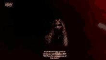 a woman with long blonde hair is standing in front of a red background with a quote on it .