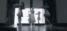 three women are dancing on a stage with coachella written on the bottom right