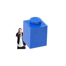 a man standing next to a large blue lego block