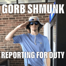 a man wearing a hat and sunglasses salutes in front of a sign that says gorb shmunk