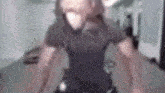 a blurry picture of a man wearing a mask while riding an exercise bike in a gym .