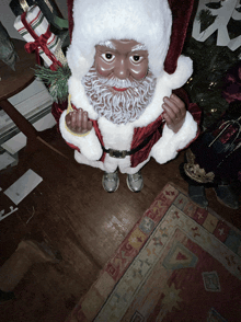 a statue of a black santa claus holding a christmas present