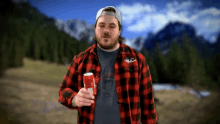 a man in a plaid shirt is holding a can of coke