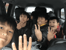 a group of young boys in the back seat of a car