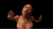 a woman in a black bra is making a funny face with her hands in the air .