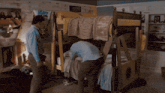 a man standing in front of a bunk bed with a poster on the wall that says ' boom ! '