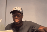 a man wearing a nike hat and a black shirt looks at the camera